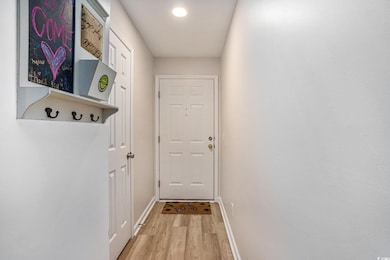 Doorway with light wood-style flooring and baseboa