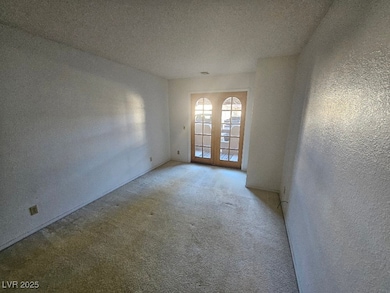 Unfurnished room with carpet, french doors, and a