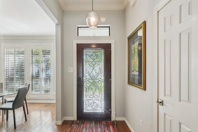 Entrance foyer featuring crown molding and wood-type flooring