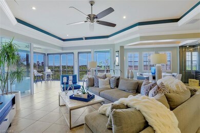 Tiled living room featuring ceiling fan, a raised 