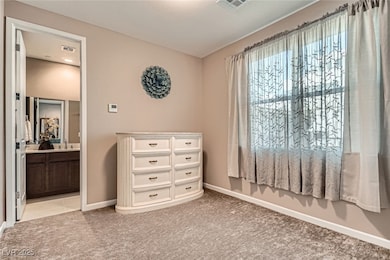 Bedroom with baseboards, light carpet, connected b