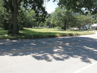 View of asphalt road with view of wooded area