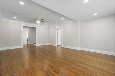 Spare room featuring crown molding, a ceiling fan, recessed lighting, baseboards, and wood finished floors