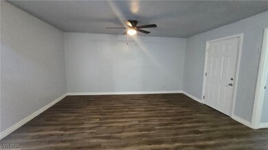 Spare room with ceiling fan, baseboards, and dark