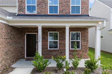 Entrance to property featuring brick siding and covered porch