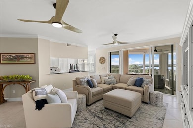 Tiled living room featuring ceiling fan and crown 