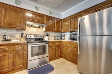 Kitchen featuring a textured ceiling, ornamental m
