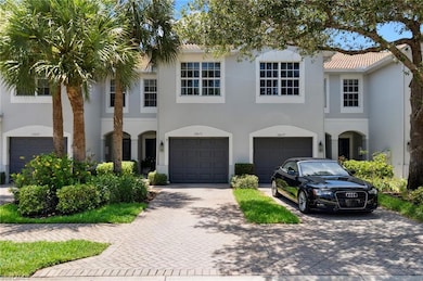 Townhome / multi-family property featuring driveway, stucco siding, and a garage