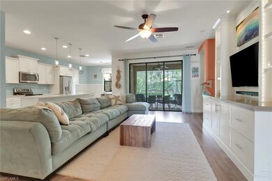 Living room with a ceiling fan, visible vents, woo
