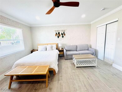 Bedroom featuring a textured wall, ornamental molding, wood finish floors, ceiling fan, and a closet