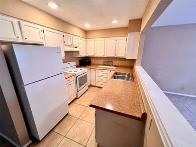 Kitchen with white appliances, light tile pattern