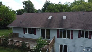 Rear view of house with a wooden deck and a shingled roof