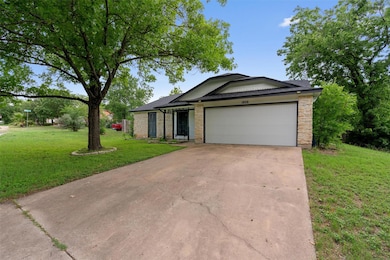 Single story home featuring a front yard, a garag