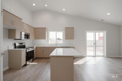 Kitchen featuring light brown cabinetry, stainless steel appliances, modern cabinets, light wood finished floors, and recessed lighting