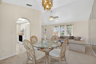 Dining space with light colored carpet, lofted cei