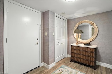 Entrance foyer featuring baseboards and light wood-style flooring - Virtually Edited Image