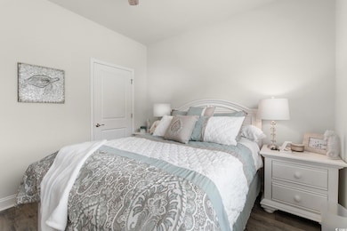 Bedroom featuring dark wood finished floors, baseboards, and ceiling fan