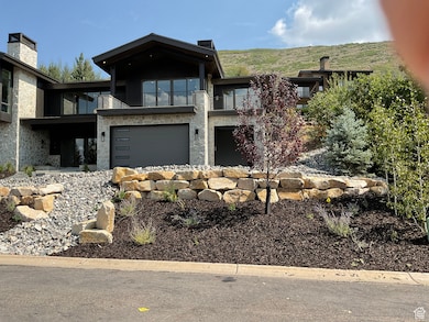 View of front of home featuring stone siding and a balcony