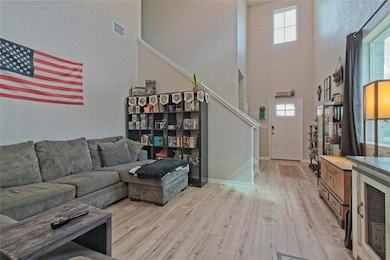 Living area with a high ceiling, light wood finis