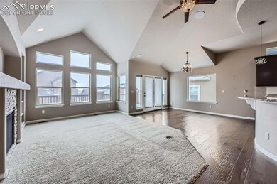 Unfurnished living room with a textured ceiling, ceiling fan with notable chandelier, dark hardwood / wood-style floors, and a fireplace