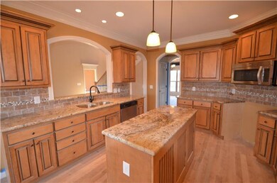 Kitchen with custom cabinets, granite, tile backsplash and solid oak hardwood flooring.