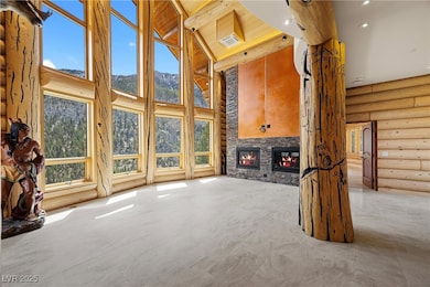 Great room featuring high vaulted ceiling, a stone