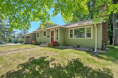 Single story home with an attached garage, a front yard, and concrete driveway