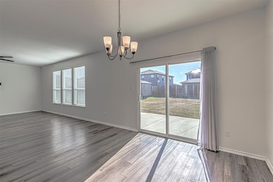 Unfurnished dining area with plenty of natural light, a chandelier, and wood finished floors
