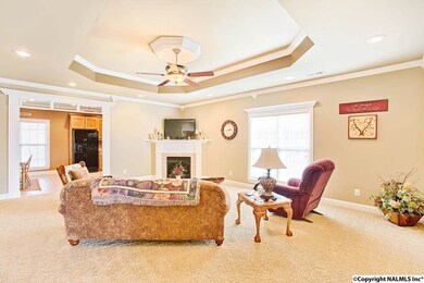 View from the foyer, this spacious room features a trey ceiling with medallion, recessed lighting, crown molding and gas log fireplace.  Notice the glass transom detail above the cased opening leading to the kitchen.