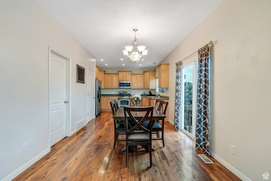 Dining room with visible vents, baseboards, dark wood-style floors, recessed lighting, and a chandelier