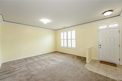 Carpeted entrance foyer featuring ornamental moldi