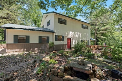 View of front of house featuring a wooden deck and a metal roof