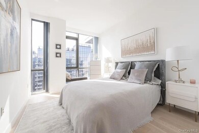 Bedroom featuring light wood finished floors and a wall of windows