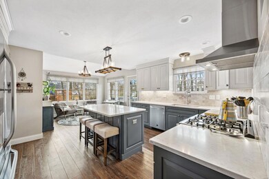 Completely renovated with luxury vinyl plank flooring, the Kitchen offers gray and white custom KraftMaid cabinetry with a center island for additional seating.