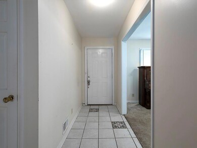Doorway featuring baseboards and light tile patterned flooring