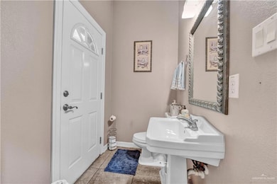 Half bathroom with tile patterned floors, toilet, and baseboards