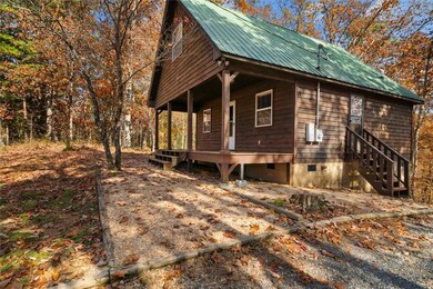 View of side of property featuring crawl space, a porch, and a metal roof