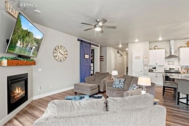 Living room with a barn door, wood finished floors