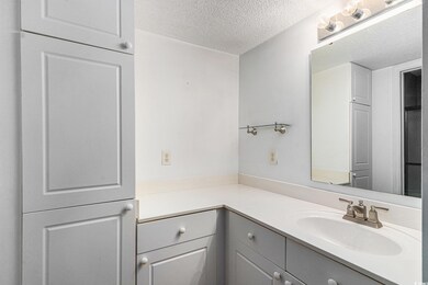 Bathroom featuring a textured ceiling and vanity