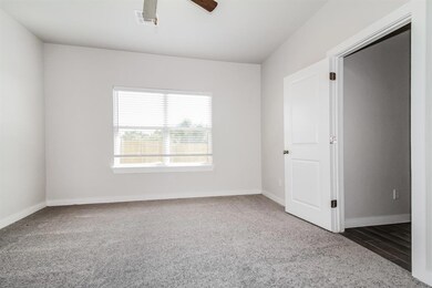 Empty room with dark carpet and ceiling fan