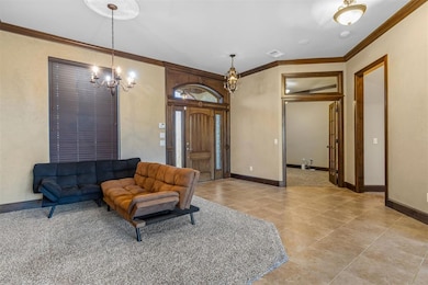 Living room with a chandelier, ornamental molding, and light tile patterned floors