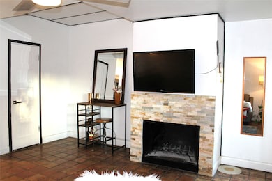 Living area featuring dark tile patterned flooring and a fireplace
