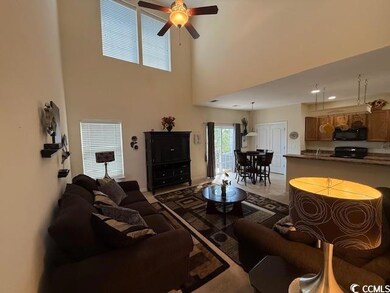 Living room with ceiling fan, carpet floors, and a