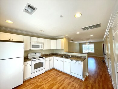 Kitchen featuring ornamental molding, white cabine