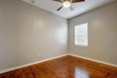Empty room with baseboards, ceiling fan, and hard