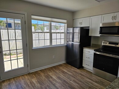 Kitchen with baseboards, dark wood-style floors, s