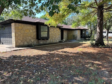 View of front of home with stone siding, an attached garage, roof with shingles, and driveway