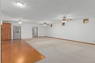 Unfurnished living room with light wood finished floors, ceiling fan, and light carpet