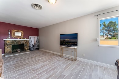 Unfurnished living room featuring a fireplace, bas