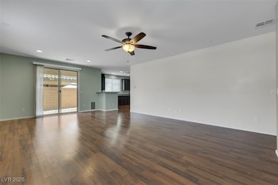 Unfurnished living room featuring a ceiling fan, d